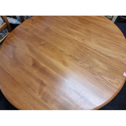 1116 - An Ercol elm drop leaf dining table, 127.5 x 140cm when open.