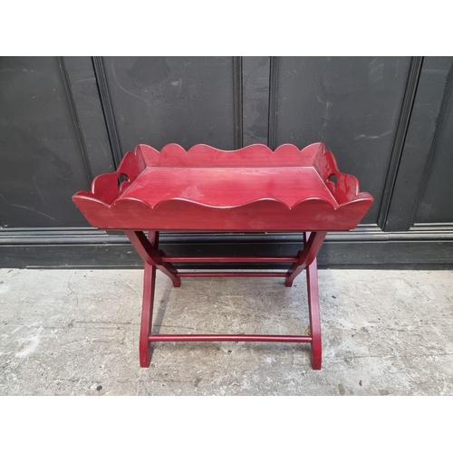 1120 - A red stained butler's tray, on conforming folding stand, 64.5cm wide.