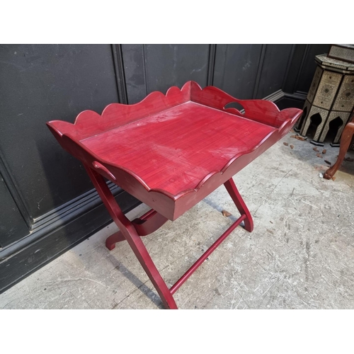 1120 - A red stained butler's tray, on conforming folding stand, 64.5cm wide.