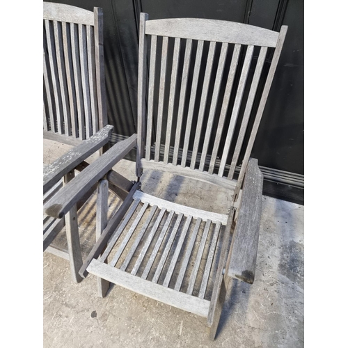 1136 - A pair of teak garden steamer chairs. (2)