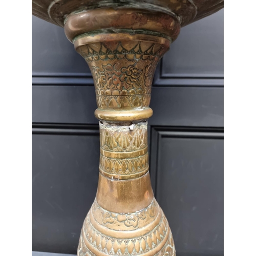 1174 - A Dutch embossed brass pedestal jardiniere, 81cm high.