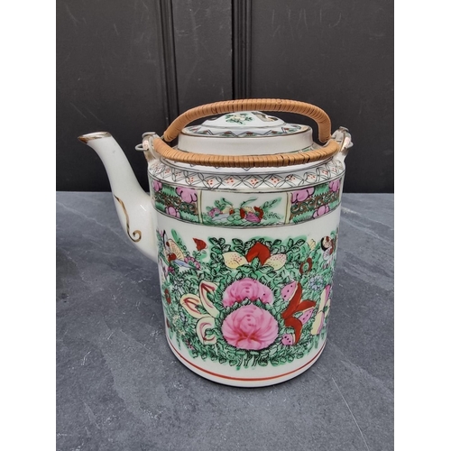 1198 - A Chinese famille rose teapot, cover and two bowls, in wicker case. (4)