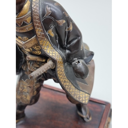 1228 - A Japanese bronze and parcel gilt figure of a Samurai, Meiji, signed Miyao, on hardwood stand, 23cm ... 