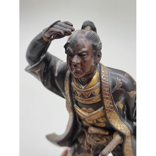 1228 - A Japanese bronze and parcel gilt figure of a Samurai, Meiji, signed Miyao, on hardwood stand, 23cm ... 