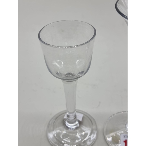 1253 - Two antique plain stem wine glasses, 16.5cm and 14cm high respectively.