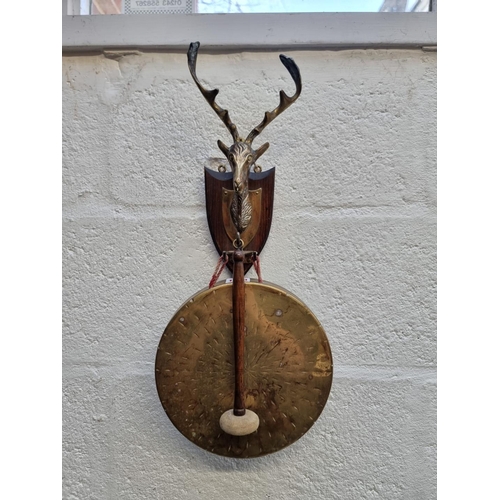 1320 - A brass and oak wall mounted dinner gong, 51cm high.