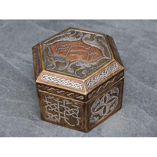 1351 - An Islamic Cairoware hexagonal casket, with script to hinged top, 10cm wide.