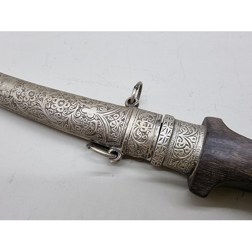 1552 - An Arab white metal mounted Jambiya and sheath, with 17.5cm decorated blade.