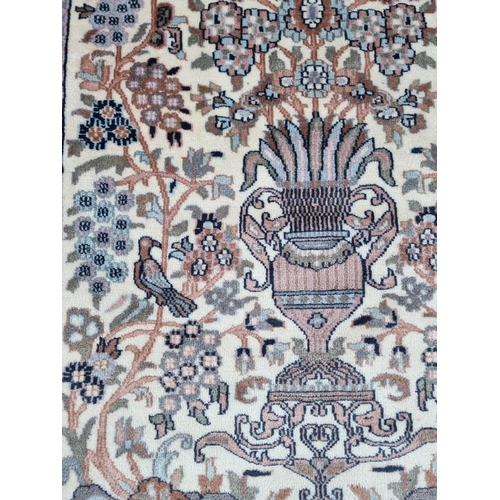 1579 - A Persian rug, central field decorated with floral urn and flowers, 196 x 121cm.