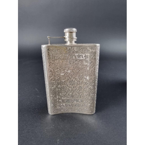 654 - An Indian white metal hip flask, having chased floral decoration, 14cm high, 181g.