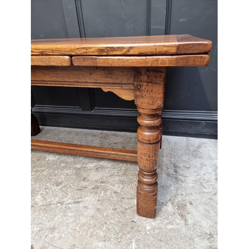 1219 - A reproduction oak draw leaf refectory table, 136.5cm when closed; together with a matching side cab... 