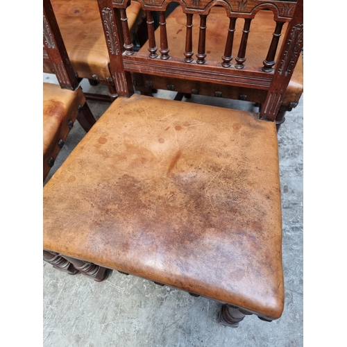 1283 - A set of four late 19th century carved walnut and embossed tanned leather dining chairs, with decora... 