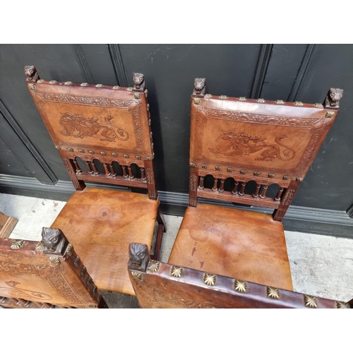 1283 - A set of four late 19th century carved walnut and embossed tanned leather dining chairs, with decora... 