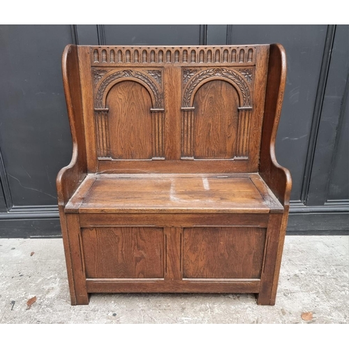 1284 - A reproduction carved oak box seat settle, 86cm wide.