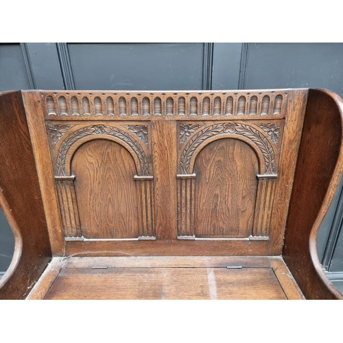 1284 - A reproduction carved oak box seat settle, 86cm wide.