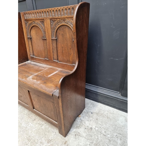 1284 - A reproduction carved oak box seat settle, 86cm wide.