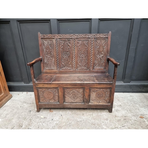 1286 - A late 17th century carved oak panelled box seat settle, 106cm wide.