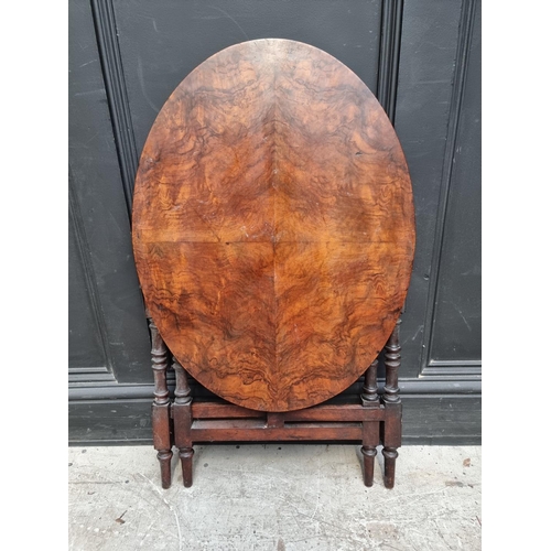 1287 - A late Victorian figured walnut oval folding table, labelled, 68.5cm wide.