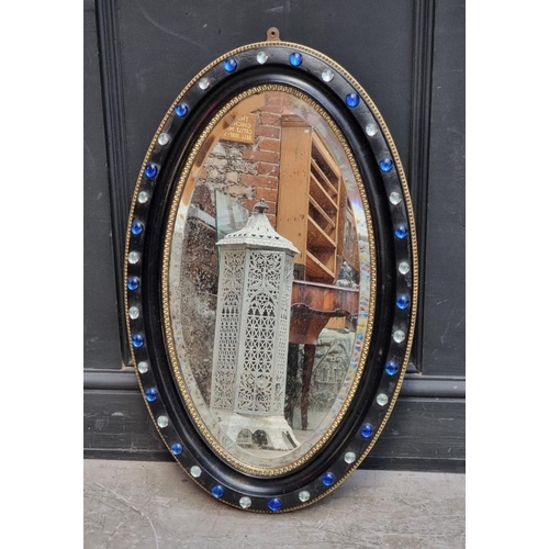 1324 - An Irish style ebonised oval wall mirror, 74 x 46cm.