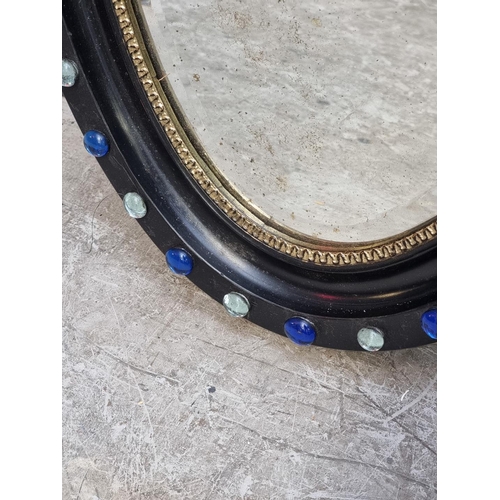 1324 - An Irish style ebonised oval wall mirror, 74 x 46cm.