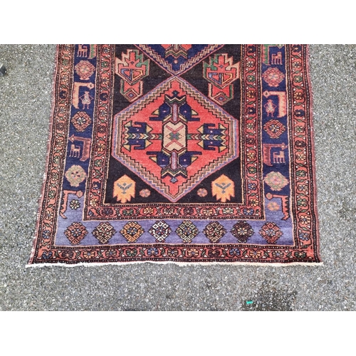 1758 - A Tribal rug, having three central medallions, borders decorated with animals, 238 x 126cm.... 