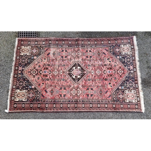 1765 - A large Persian rug, with central diamond medallion, with floral decoration, 264 x 161cm.... 