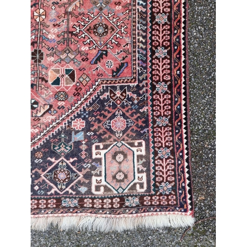 1765 - A large Persian rug, with central diamond medallion, with floral decoration, 264 x 161cm.... 