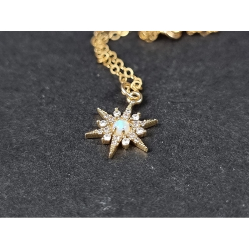 1002 - A yellow metal chain, stamped 14k, with star shaped pendant set cabochon opal and white gemstones.... 