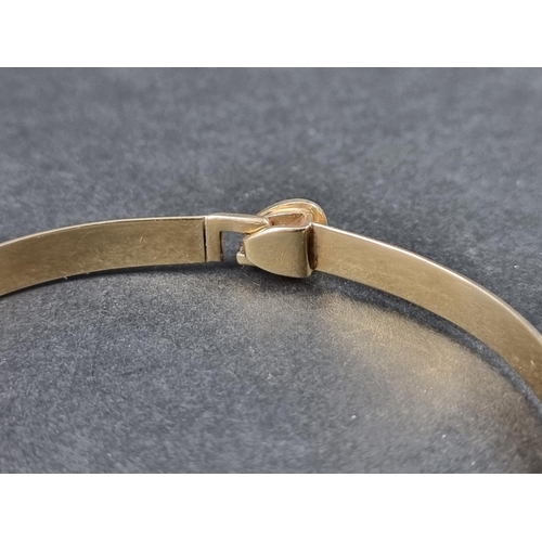 1027 - A continental yellow metal bangle, having heart shaped clasp, stamped '375'.