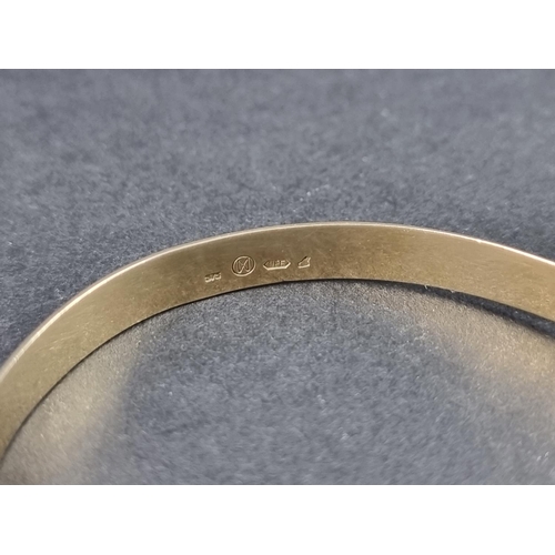 1027 - A continental yellow metal bangle, having heart shaped clasp, stamped '375'.