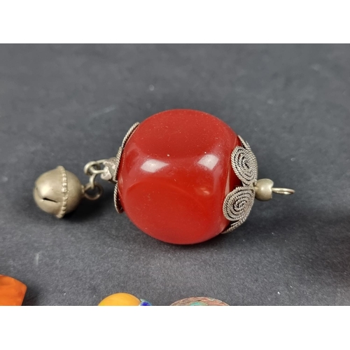 1102 - Two large Bakelite 'cherry amber' beads, one mounted as a pendant; and three other items. (5)... 