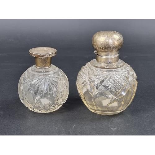 669 - Two silver lidded cut glass scent bottles, largest 11.5cm high.