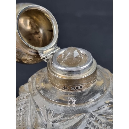 669 - Two silver lidded cut glass scent bottles, largest 11.5cm high.