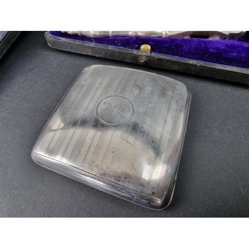 694 - A cased silver shell butter dish; together with a silver cigarette case, 150g; and a cased pair of p... 