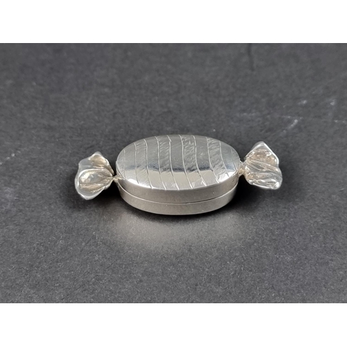 745 - A silver novelty 'sweet' pill box, import mark C M E Jewellery Ltd, Birmingham, 5.7cm wide.... 