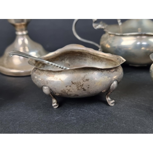 801 - A group of silver, to include: a set of four oval salts, with three spoons; a small pair of silver c... 