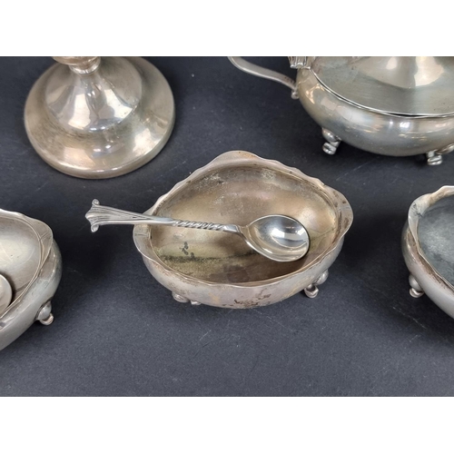 801 - A group of silver, to include: a set of four oval salts, with three spoons; a small pair of silver c... 