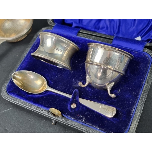 818 - A cased Edwardian silver egg cup, spoon and napkin ring, by CJ DF, London 1911; together with a silv... 