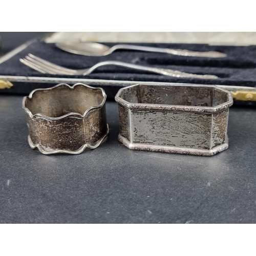 824 - Six various silver napkin rings; together with a cased silver Christening fork and spoon, 244g.... 