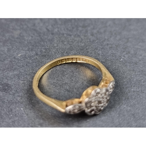 914 - An 18ct gold daisy ring, set seven small diamonds with a further diamond to each shoulder, size M, g... 