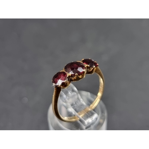 930 - A yellow metal ruby three stone ring, stamped 18ct, size M.