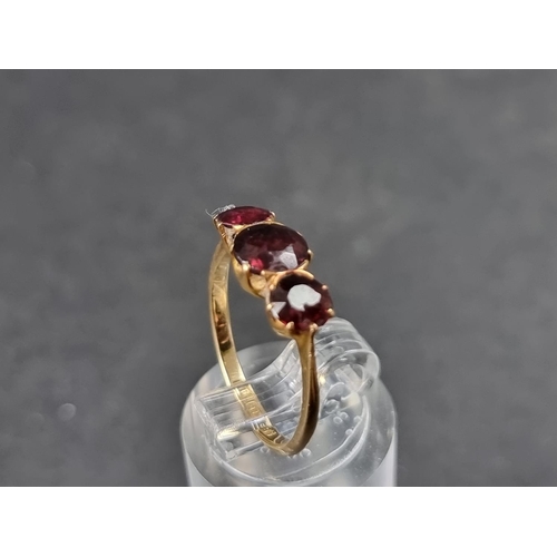 930 - A yellow metal ruby three stone ring, stamped 18ct, size M.