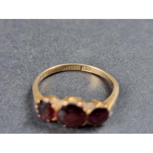 930 - A yellow metal ruby three stone ring, stamped 18ct, size M.