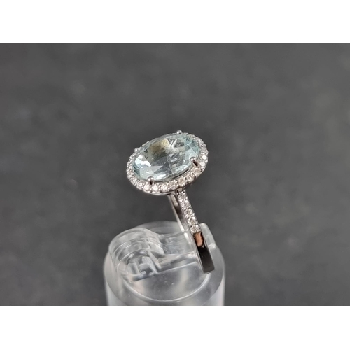 932 - A white metal ring, set central faceted aquamarine of approx. 2.60ct, surrounded by small brilliant ... 