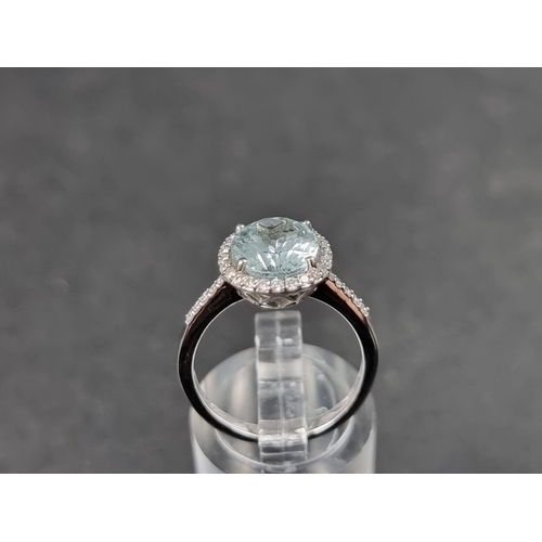 932 - A white metal ring, set central faceted aquamarine of approx. 2.60ct, surrounded by small brilliant ... 