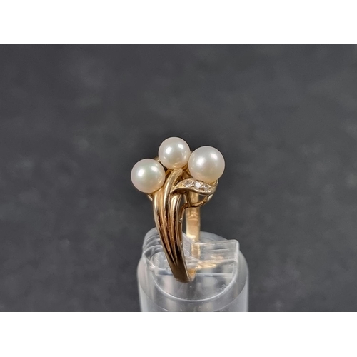 934 - A yellow metal ring, set three pearls and three small diamonds, stamped 14k, size L.... 