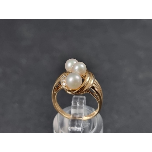 934 - A yellow metal ring, set three pearls and three small diamonds, stamped 14k, size L.... 