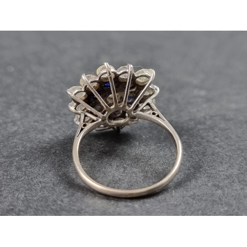 937 - A diamond and sapphire floral cluster ring, set central brilliant cut diamond surrounded by a row of... 