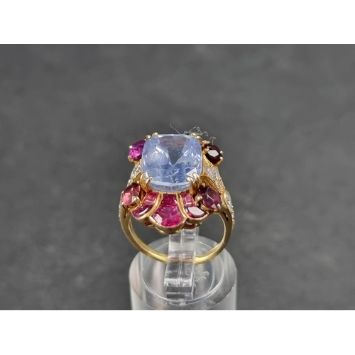 941 - A yellow metal cocktail ring, set central blue topaz surrounded by rubies and diamonds, size K 1/2.... 