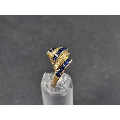 944 - A yellow metal ring, having five rows of pave set sapphires and diamonds, stamped '18k', size N.... 